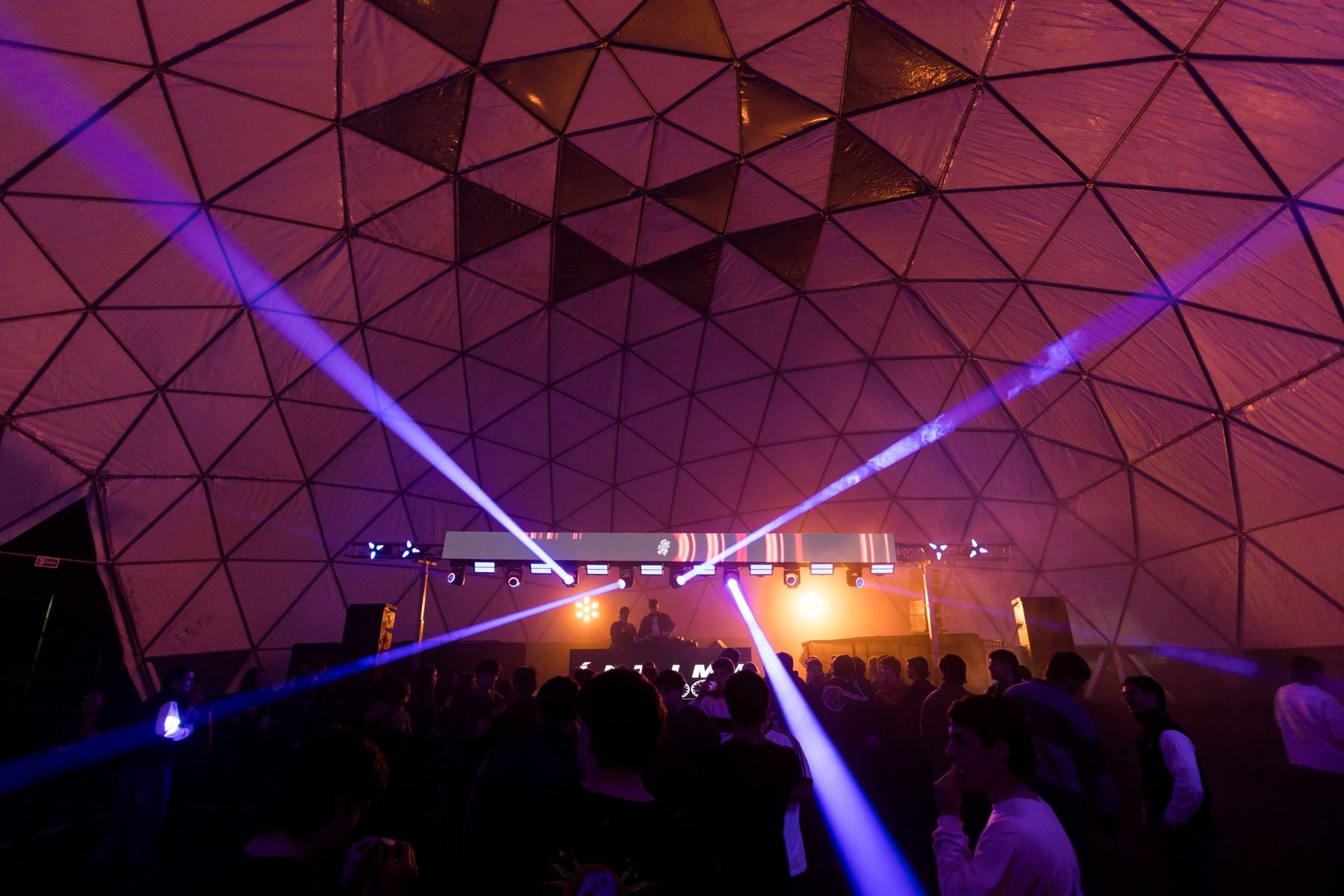 Fiesta de noche en el domo con haces de luz y escenario